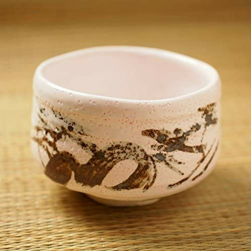 A Mino ware matcha tea bowl in the Momoyama Shino style — the thick, warm white feldspar glaze with a faint blush where the fire touched it