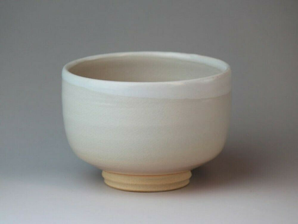 A classic Hagi-ware chawan in a soft, milky white-cream glaze with fine crackle visible near the rim