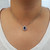 Tanzanite and diamond halo pendant on neck