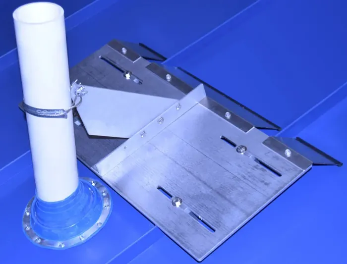 VentSaver snow diverter with standing seam mounting plate installed beside a roof vent pipe