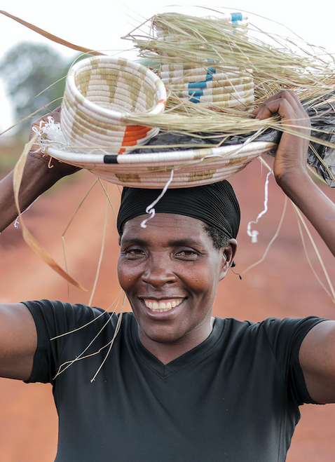 WomenCraft weaver carrying product back to camp