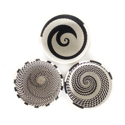 Black and white small bowls woven out of discarded telephone wire.