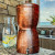 Our Sertodo Sana Vida Ayurvedic Copper Gravity Water Filter System on a marble countertop, with a stone wall in the background. In the background is the kitchen window showing a vibrant ocean view.