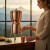 Woman enjoys our Sertodo Sana Vida Ayurvedic Copper Gravity Water Filter as a hydration centerpiece in a mountain inspired kitchen.