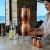 Woman enjoys our a moment of water inspiration with her Sertodo Sana Vida Ayurvedic Copper Gravity Water Filter in an ocean inspired kitchen.