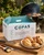 Cops Farm Shop BBQ Chicken Box Content and boxdisplayed in front of a bbq