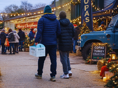 2 people carrying a box walk through a christmas fair
