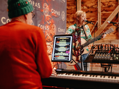 a band in Christmas jumpers play at a festive event