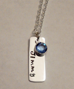 Hand Stamped Rectangle Name Tag Sterling Silver with Genuine Swarovski Crystal Birthstone Necklace and choice of chain. It is shown with a Polished Finish on a Solid Sterling Silver Cable Chain. Choose from five custom finish options. Use the drop down menu to add Genuine Swarovski Birthstones.

SIZE: 
Solid Sterling Silver 20 gauge Rectangle Name Tag approx. 1" x 1/4"
One Genuine Swarovski Crystal Birthstone choice
