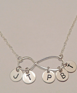My Forever Family Large Infinity Symbol with Hanging Hand Stamped Initial Charms, all Sterling Silver Necklace. It is shown with a Polished Finish on a Solid Sterling Silver Cable Chain. Choose from five custom finishes. This item is available only on select Cable Chains. To add Solid Sterling Silver 1/4" Round Initial Charm Initial Charms, use the drop down menu. Use the drop down menu if you would like to add crystal birthstones. 
 
SIZE: 
Solid Sterling Silver Infinity Symbol Approx. 1 1/5"x2/5"
Solid Sterling Silver 1/4" Round Initial Charm (Not included, but can be added using drop down menu)
