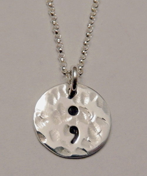 Semicolon Sterling Silver Small Circle Hand Stamped Necklace and choice of chain. ~ Project Semicolon ~ Depression, Suicide, Addiction & Self-Injury Recovery & Prevention . Choose from five custom finish options. It is shown Hammered on a Rolo Chain. Use the drop down menu to add Genuine Swarovski Birthstones.
 
This piece is inspired by the Project Semicolon Movement. Project Semicolon (The Semicolon Project) is a faith-based non-profit movement dedicated to presenting hope and love to those who are struggling with depression, suicide, addiction and self-injury. "A semicolon represents a sentence the author could have ended, but chose not to. The sentence is your life and the author is you." - Project Semicolon
 
SIZE: 
Solid Sterling Silver 1/2" Round