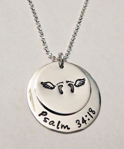 Stamped Infant Loss Necklace ~ Sterling Silver Child Memorial Necklace ~ "Psalm 34:18" Baby Feet & Angel Wings Remembrance Necklace. It is shown with a Polished Finish on a Diamond Cut Bead Chain. Choose from five custom finish options. You can have a Date or Name below the baby feet if you like, or customize the text on the larger piece of silver. Use the drop down menu to add Genuine Swarovski Birthstones.

Psalm 34:18 NIV 
The Lord is close to the brokenhearted and saves those who are crushed in spirit.

SIZE:
Solid Sterling Silver 1" Round with "Always in my heart" or custom text
Solid Sterling Silver 3/4" Round with baby feet and angel wings (optional name, date, other custom text)