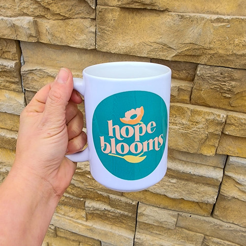 Handwash only 15 oz. white ceramic mug featuring "Hope Blooms" artwork