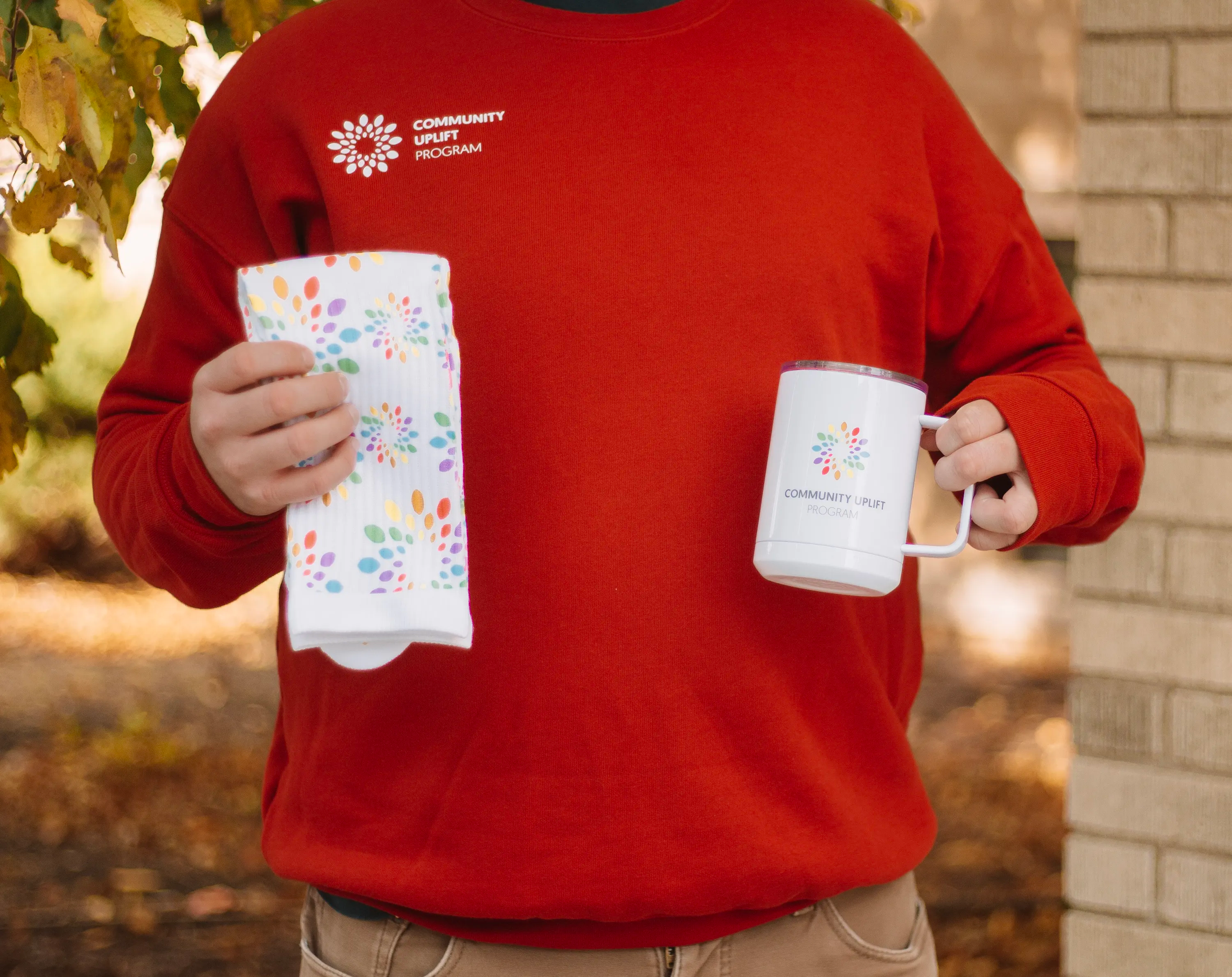 Man wearing CUP crewneck and holding promo items