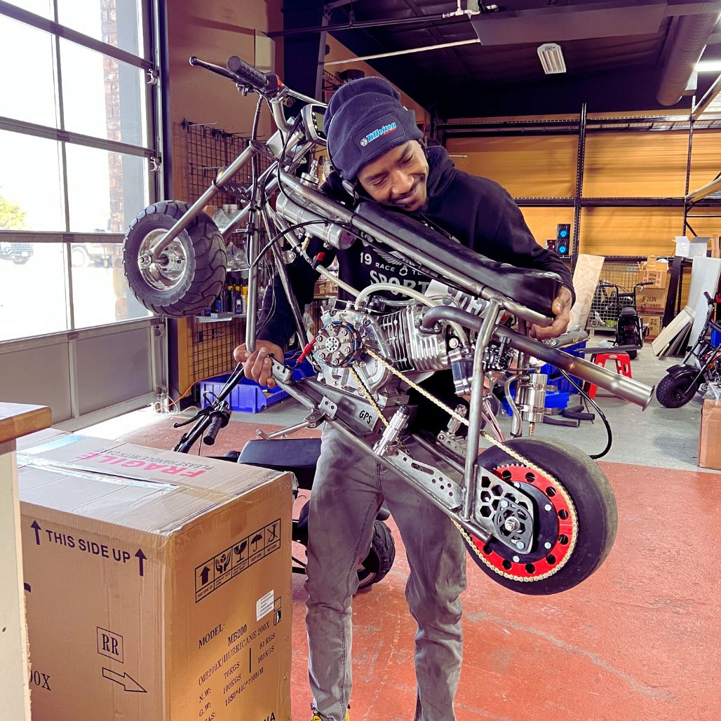 Rascal GT Mini Bike Drag Kit (RASCALGTDRAG) being held by Flacco like a baby.