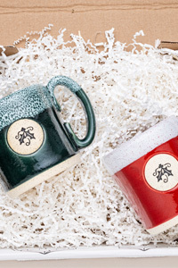 Red and green stoneware mugs with a holly motif