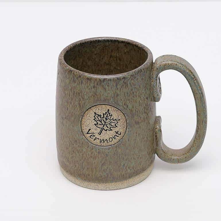 Greenish brown pottery tavern mugh with a maple leaf and the word Vermont on the side