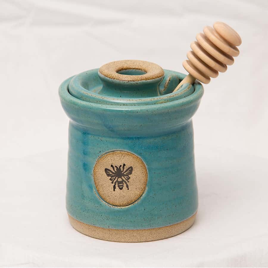 turquoise pottery honey pot with a bee stamped on it