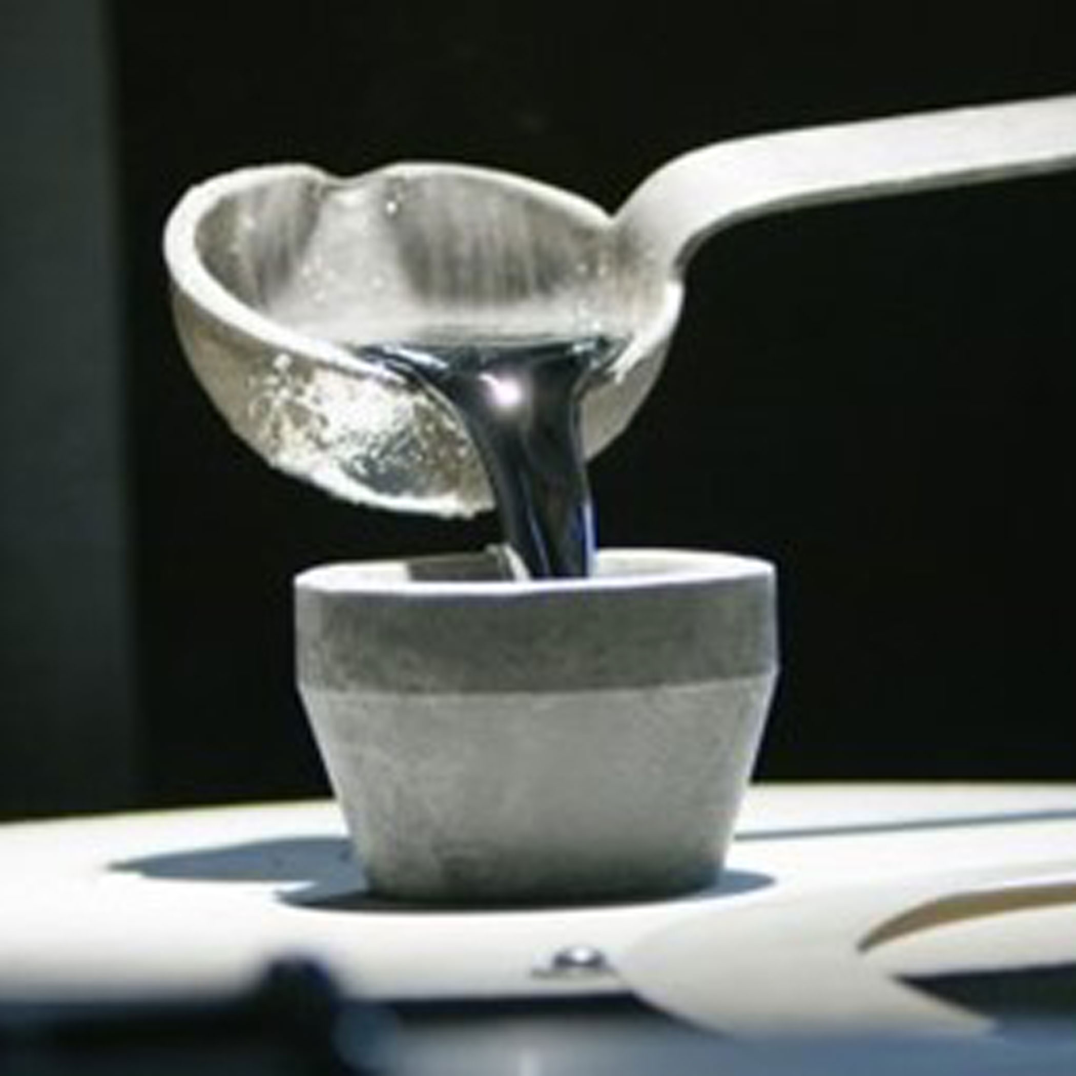 Ladle pouring molten pewter