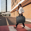 lifestyle image with person carrying garment bag