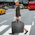 lifestyle image of woman carrying garment bag