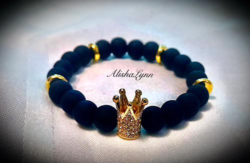 Black matte beads with gold tone spacers and crown. Black matte beads with gold tone spacers and crown.