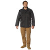 Rothco M-65 Storm Jacket M65SJ, man wearing a black military-style waterproof jacket with multiple front pockets and a high collar, paired with tan cargo pants and tan boots. Thumbnail Image