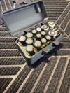 LAPG Battery Storage Box TDP-SQBATTHOLDER, black plastic battery storage case with multiple AA batteries inside, on textured black rubber mat. Thumbnail Image