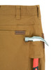 Iron & Haft Men's Tradesman 12 Pocket Stretch Work Pant, close-up of khaki work pants with a hammer and a red-handled tool in the pockets.