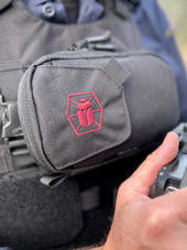 Kitanica Flip Admin Pouch 112-KN, close-up of the tactical black pouch attached to a backpack with a pink logo embroidered on it. Thumbnail Image