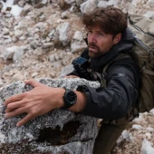 Suunto Core 2 Classic Outdoor Watch, a rugged black outdoor watch worn by a hiker climbing rocky terrain outdoors. Thumbnail Image