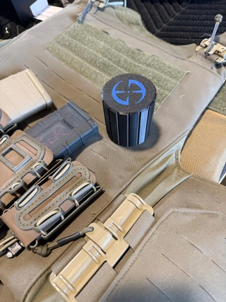 LAPG Tactical Spare Battery Container TDP-RDBATTHOLDER, black cylindrical container with blue logo on top, placed on tactical gear with pouches and straps.