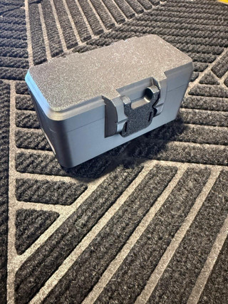 LAPG Battery Storage Box, TDP-SQBATTHOLDER, a gray rectangular plastic case with a textured lid and a black latch, designed for organizing and storing batteries.