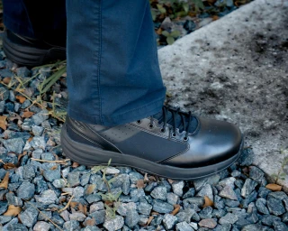 OTB Boots Fusion 6 Black Tactical Boot, close-up of a person's foot wearing the black tactical boot on rocky terrain.