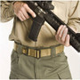 Blackhawk Coyote CQB/Rigger's Belt on green khakis while model holds item