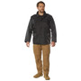 Rothco M-65 Storm Jacket M65SJ, man wearing a black military-style waterproof jacket with multiple front pockets and a high collar, paired with tan cargo pants and tan boots.