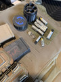 LAPG Tactical Spare Battery Container, TDP-RDBATTHOLDER, black cylindrical battery holder with multiple slots for batteries, placed on a tactical gear surface with batteries and other equipment.