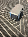 LAPG Battery Storage Box TDP-SQBATTHOLDER, rugged black and gray portable battery holder with protective casing on a textured rubber mat.