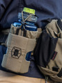 Kitanica Water Bottle Holster 110-KN, tactical nylon water bottle holder with elastic top for a 32 oz water bottle and attached survival gear, in a neutral tactical color on outdoor gear.