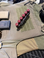 LAPG Shotgun Shell Holder - 3 Pack, black plastic holder with six red shotgun shells, placed on tactical gear with magazine pouches and knife.