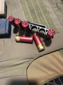 LAPG Shotgun Shell Holder - 3 Pack, red shotgun shells with brass bases and a black metal holder on a tactical surface.