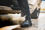 OTB Boots Fusion 6 Black Tactical Boot, close-up of a person wearing black combat boots stepping out of a vehicle.