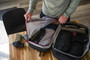 Vertx Urban Ghost Utility Pouch VTX5313, organized on a desktop with travel gear including gun holster, portable speaker, socks, and a pouch inside a duffel bag