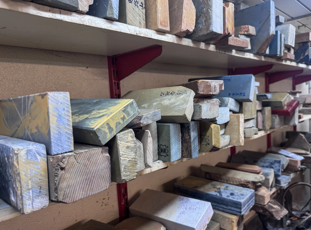 Shelves of Japanese natural sharpening stones in the JNS workshop