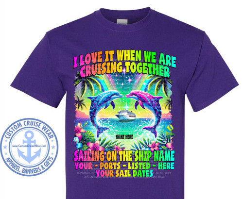 The image displays a purple t-shirt with a vibrant graphic design printed on the front. The design is centered and occupies a significant portion of the shirt.

The main elements of the graphic are:
• Text: The primary text reads "I LOVE IT WHEN WE ARE CRUISING TOGETHER" in large, colorful, gradient letters transitioning from pink to green. Below this, in slightly smaller, block letters, it says "SAILING ON THE SHIP NAME". Further down, in bold, capitalized letters, are placeholders: "YOUR PORTS - LISTED - HERE" and "YOUR SAIL DATES". The word "NAME HERE" is also present as a smaller placeholder in the middle. The text is decorated with subtle starbursts and rainbow effects.
• Dolphins: Two dolphins, one blue and one pink, are depicted jumping out of the water, facing each other. They have an iridescent, almost magical appearance with vibrant purple and blue accents.
• Cruise Ship: A detailed image of a modern cruise ship is positioned between the two dolphins, sailing on the water.
• Scenery: The background depicts a tropical paradise. Palm trees flank the scene, and the water below is a bright, sparkling blue. The foreground is filled with lush, colorful tropical flowers and leaves, including hibiscus and foliage in shades of pink, purple, and green. There are also hints of a rainbow arcing across the sky behind the text.
• Water Effects: Splashes and foam are rendered around the dolphins and the cruise ship, creating a sense of movement and energy.
• Color Palette: The design is dominated by bright, saturated colors, including pink, purple, blue, green, yellow, and orange. The overall effect is cheerful and summery.
• Composition: The design is symmetrical, with the dolphins and palm trees balanced on either side. The text is arranged in a layered manner, guiding the viewer's eye from the main slogan to the customizable details.
• Branding: A circular logo for "CUSTOM CRUISE WEAR" is placed on the lower left side of the t-shirt, outside the main graphic area. It features an anchor symbol and the website address "www.CustomCruiseWear.com".

Subtle details include the starry background elements, the gradient color transitions in the text and dolphins, and the detailed rendering of the cruise ship and tropical flora. The t-shirt itself is a solid, deep purple color, which serves as a dark canvas for the bright and energetic graphic. The image is a product shot, showcasing the design on the apparel.
