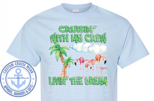 The image shows a light blue t-shirt with a graphic design printed on the front. The graphic features a tropical scene with text and flamingos.

The text at the top of the graphic reads "CRUISIN' WITH MY CREW" in a playful, slightly irregular font with a lime green outline and a white fill. The letters appear to have a subtle shadow or texture.

Below the text, there are stylized white clouds with soft, rounded edges. To the left of the clouds, there is a tall, textured palm tree with green fronds.

In front of the clouds and palm tree, a line of flamingos is depicted. There are five flamingos in varying sizes, suggesting a family or group. They are primarily pink with black beak tips and black markings on their wings. The flamingos are painted in a watercolor style, with visible brushstrokes and soft color blending. One larger flamingo stands prominently on the right, with its neck curved. To its left, a smaller flamingo is shown. The line continues with even smaller flamingos towards the center.

At the bottom of the graphic, the text "LIVIN' THE DREAM" is written in the same lime green outlined font as the top text. The letters here are also slightly irregular and textured.

On the left side of the t-shirt, there is a circular emblem with a blue outline and a lighter blue fill. The emblem reads "CUSTOM CRUISE WEAR" in an arc at the top, with stars flanking the text. In the center of the emblem is a stylized anchor with a rope wrapped around it, in a darker blue color. Below the anchor, in a smaller font, it says "www.CustomCruiseWear.com". The bottom arc of the emblem reads "APPAREL, BANNERS & GIFTS".

The t-shirt itself is a light pastel blue. The background of the image is plain white, with a subtle watermark of the words "CUSTOM CRUISE WEAR" and "COPYRIGHT - DO NOT COPY" repeated in a light gray, semi-transparent pattern across the entire t-shirt and graphic area. The Gildan brand label is visible at the neckline.

The composition places the graphic centrally on the t-shirt, with the emblem to the lower left. The overall color palette is dominated by the light blue of the shirt, the vibrant pinks and greens of the graphic, and the blue of the emblem. The design evokes a sense of vacation, relaxation, and camaraderie, likely associated with a cruise.