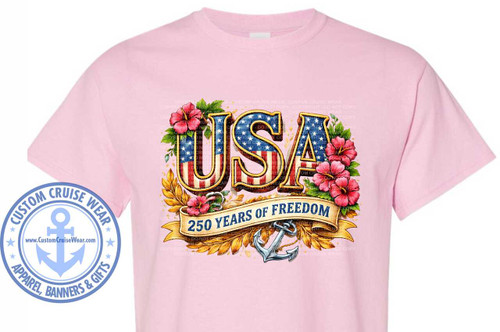 The image displays a light pink t-shirt with a patriotic graphic design centered on the chest. The graphic features the word "USA" in large, bold, stylized letters. Each letter is filled with a pattern resembling the American flag, with blue fields and white stars on the left side of the "U" and "S", and alternating red and white stripes throughout. The letters have a thick, metallic gold outline with a subtle shadow effect, giving them a raised appearance.

Surrounding the "USA" letters are decorative elements. On the left and right sides, there are clusters of bright pink hibiscus flowers with dark centers. Green leaves and vines intermingle with the flowers and letters. At the bottom, a golden laurel wreath forms a base for the design. Across the lower part of the graphic, a tan ribbon is draped, bearing the text "250 YEARS OF FREEDOM" in dark blue, sans-serif font. Below the ribbon, a silver anchor with a coiled rope is prominently displayed, symbolizing a connection to maritime themes or perhaps freedom and stability.

On the left side of the t-shirt, outside the main graphic, is a circular logo. The logo has a light blue outer ring with white stars and the text "CUSTOM CRUISE WEAR" in capital letters along the top curve and "APPAREL, BANNERS & GIFTS" along the bottom curve. Inside this ring is a smaller circular emblem with a dark blue border and a large, light blue anchor symbol at its center. The website "www.CustomCruiseWear.com" is printed in white text on a dark blue background within this inner circle.

The background of the graphic area on the t-shirt has a subtle, semi-transparent watermark pattern that reads "CUSTOM CRUISE WEAR - COPYRIGHT - DO NOT COPY". The overall color palette is dominated by the red, white, and blue of the American flag, accented by the gold, pink, and silver elements. The composition is balanced, with the large "USA" text as the focal point, supported by the surrounding embellishments and text. The t-shirt itself is a soft, pastel pink, providing a gentle contrast to the vibrant graphic.