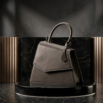 Grey leather handbag with top handle displayed