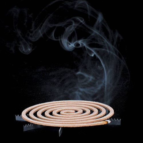 Dark view of the Lifesystems Mosquito Coil on a stand that has been lit and is showing the smoke produced as it works