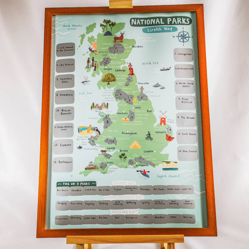 Full view of a framed map of the National Parks Scratch Off Map on a stand